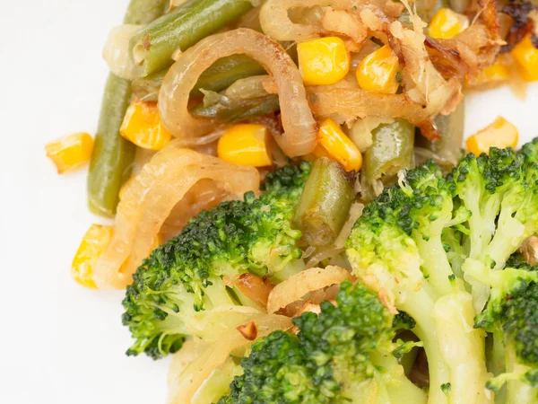 Gekochtes Gemüse Brokkoli, Karotten, grüne Bohnen, Mais auf einem weißen Teller. Makro — Stockfoto