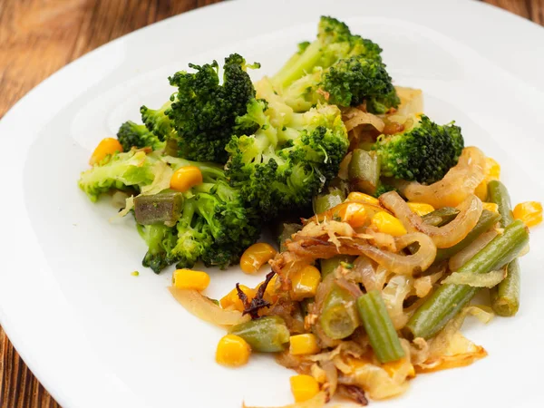 Варені овочі брокколі, морква, зелена квасоля, кукурудза на білій тарілці. макрос — стокове фото