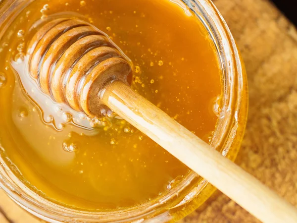 Honey with wooden mixer top left view — Stock Photo, Image