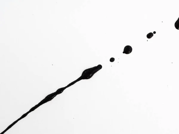 Derrama pintura negra aislada sobre fondo blanco. Salpicaduras de fuelóleo, gotas y rastro — Foto de Stock