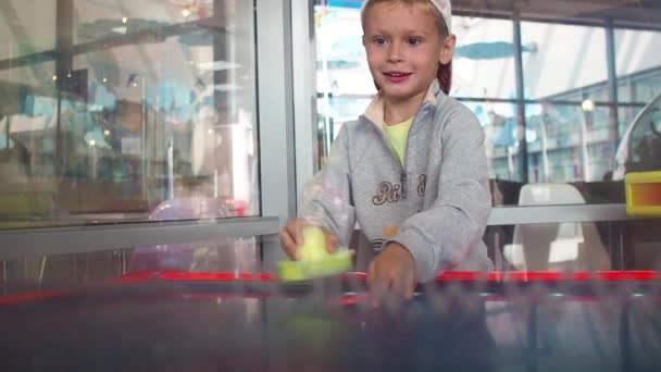 Маленький хлопчик грає в повітряний хокей з емоціями — стокове відео