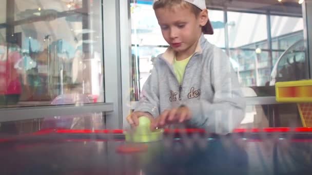 Kleiner Junge spielt Airhockey mit Emotionen Zeitlupe — Stockvideo