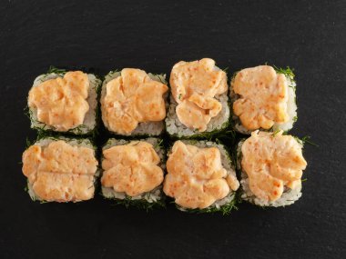 ahşap arka planda gri taş arduvaz üzerinde suşi rulo