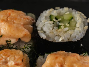 ahşap arka planda gri taş arduvaz üzerinde suşi rulo