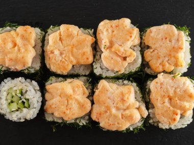 ahşap arka planda gri taş arduvaz üzerinde suşi rulo