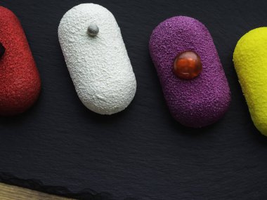 Arduvaz ve ahşap arka planda renkli tatlı pasta tatlı Mini kek seçimi