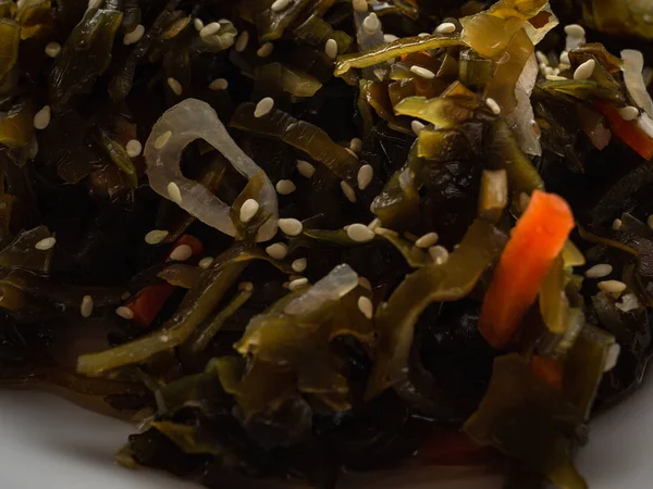Салат з морськими водоростями з насінням кунжуту на білій тарілці — стокове фото