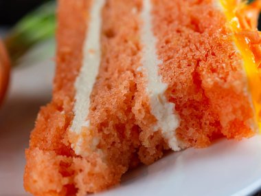 Isırılmış bir parça havuçlu kek beyaz bir tabakta yatıyor..