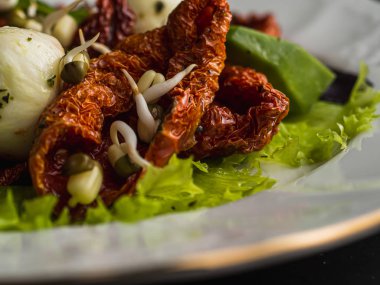Kurutulmuş domateslerden, pe-tsai, avokado ve mozzarella peynirinden yapılmış salata. yakın plan.