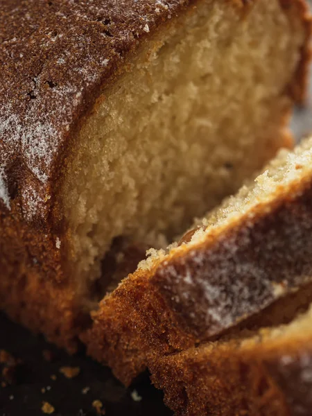 Rectangular loaf cut into pieces with a white sprinkle is on a rusty protvin.