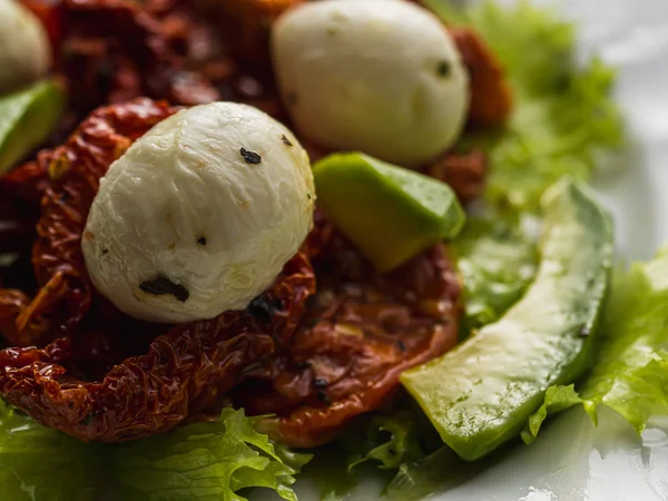 Salat aus getrockneten Tomaten, Pe-Tsai, Avocado und Mozzarella. Nahaufnahme. — Stockfoto