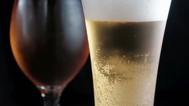 Dvě zamlžená skla se studeným světlem a tmavým pivem. bubliny. stock záběry. — Stock video