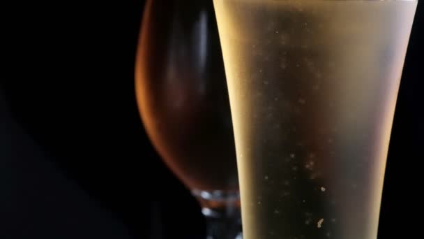 Due vetro nebulizzato con luce fredda e birra scura. Bolle. stock di filmati. — Video Stock