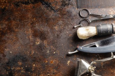 Paslı bir yüzeyde eski kuaför aletleri vardır. Manüel makas, tarak, jilet, tıraş fırçası. Kırsal kesim. yatay oryantasyon. Üst manzara düz ley. Boşluğu kopyala.