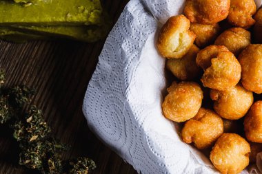 Churros, tıbbi kenevir yağından, şekerden, undan, yumurtadan İspanyol çörekleri toplar. Marihuana tomurcukları. Tıbbi kenevir yağı. Paslı bir yemek tepsisinin üzerinde. yatay yönelim.