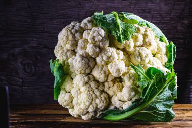 Eski ahşap arka planda taze çiğ organik çirkin karnabahar. Vejetaryen yemek tarifi ya da menü geçmişi. yatay