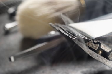 Paslı bir yüzeyde eski kuaför aletleri vardır. Manüel makas, jilet, tıraş fırçası. Kapat. Kırsal kesim. Yatay. kopyalama alanı. buharlı araçlar