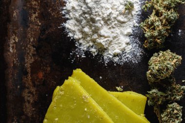 rustik kenevir yağı ve tıbbi marihuana tomurcuğu ve eski paslı metal damlatma tavasında un. Eski ahşap arka plan. yatay oryantasyon. yakın plan.