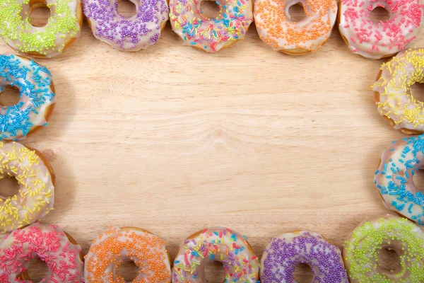 Flache Lageansicht Vieler Gefrosteter Donuts Mit Bonbonstreuern Einem Randrahmen Auf — Stockfoto