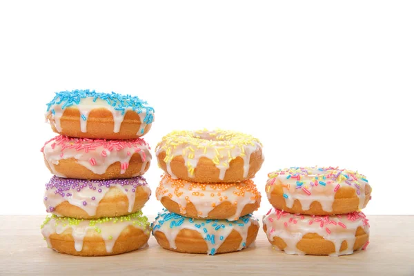 Многие Красочные Глазированные Пончики Торт Конфетными Брызгами Сложены Ряды Лежащие — стоковое фото