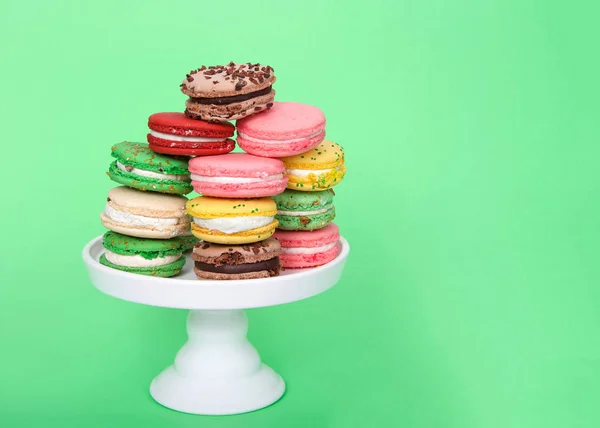 Biscoitos Macaron Várias Cores Primavera Empilhados Pedestal Branco Fundo Verde — Fotografia de Stock