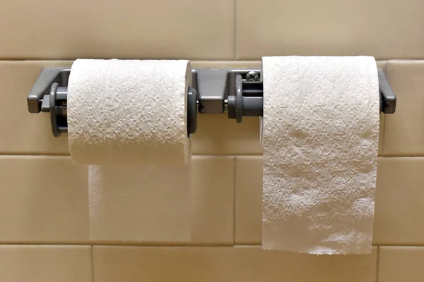 Double toilet paper roll holder, one roll coming under one roll going over.