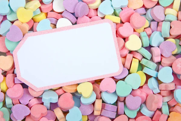 色彩鲜艳的糖果心 白色卡片与粉红色边框放在顶部复制空间 情人节 图库图片