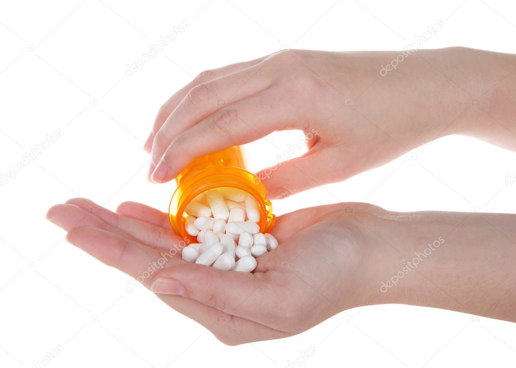 Young caucasian hand pouring pain pills from prescription bottle into other hand. Opioid epidemic