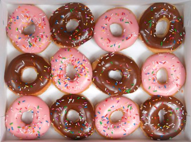 Üst görünüm düz bir düzine sırlı donut yatıyordu, beyaz bir kutu izole çilek ve çikolata alternatif. Donutlar yeni bir moda veya yeni bir eğilim haline mi. Gurme tarzı fantezi çörekler.