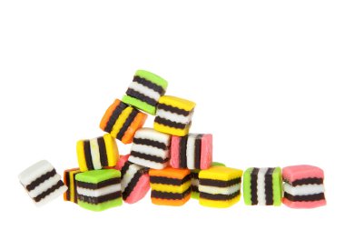 Colorful fancy licorice candy squares piled randomly spilling to one side isolated on white clipart