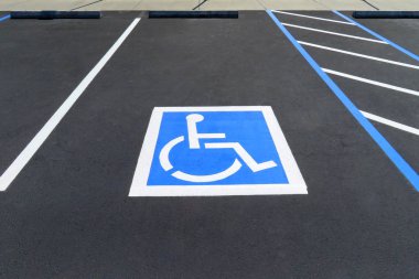 Freshly resurfaced and repainted handicap parking space in a parking lot. The number of handicap spaces increases with the size of the lot, requiring roughly one handicapped spot per 25 spaces. clipart