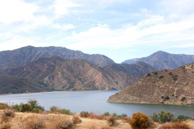 Bulutlu mavi gökyüzü arkaplanlı Piramit Gölü 'nün yarısı görünüyor. Piramit Gölü kayık, balıkçılık, jet ski ve piknik alanları sunar, bunların arasında sadece tekneyle ulaşılabilen beş eşsiz alan da vardır.