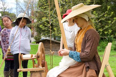 Fairfield, CA - April 6, 2019: Unidentified participants at the Tartan Festival, a Scottish living history festival hosted by the East Bay Scots at Ardenwood Farms. Woman spinning wool into thread.