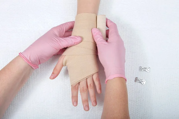 Young Female Hands Wearing Pink Gloves Wrapping Elastic Ace Bandage — ストック写真