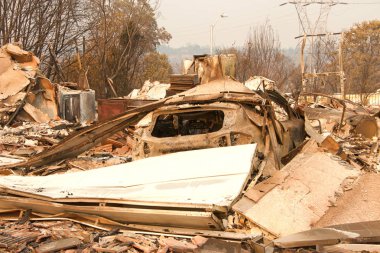 Ev yanıp kül oldu, garaj kapısı Redding, Ca 'daki yakın zamanda çıkan yangından sonra bir yığın haline geldi. Ateş kilometrelerce uzakta yanmaya devam ederken duman ve kül havada..