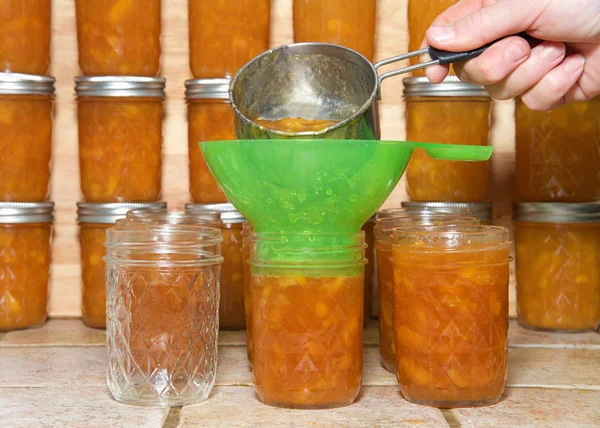 Ältere Frauenhand Mit Messbecher Voll Frisch Gekochter Pfirsichmarmelade Die Durch — Stockfoto