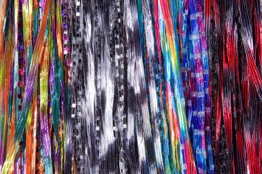 Arka plan kumaş telleri eşarp yaratıyor, birden fazla renkli eşarp sıralarda sallanıyor. sarı, kırmızı, mavi, mor, kestane rengi, su, siyah, beyaz