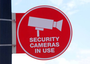 Kırmızı Güvenlik Kameraları mavi bulutlu arka planda bir direkte kullanım işareti var. Suçluların eylemleri kaydedilecek..