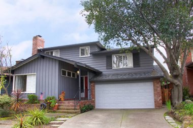 İki katlı çiftlik evi, kırmızı tuğlalı gri ahşap kaplama. Çiftlik stili, ABD kökenli bir yerli mimari tarzdır..