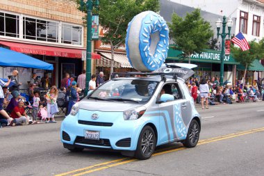 Alameda, Ca - 4 Temmuz 2018: Alameda 4 Temmuz Geçidi, ülkenin en büyük ve en uzun Bağımsızlık Günü geçit törenlerinden biridir. Donut Petit arabasının üzerinde büyük bir çörek olan kimliği belirsiz katılımcılar..