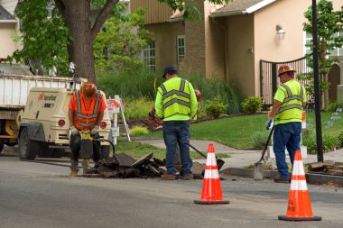 Alameda, Ca - 11 Temmuz 2018: İlçe çalışanları ağaç kökleri tarafından hasar gören yolları onarıyor. Kök kaldırma, bazen kaldırım kaldırma denir, yeterli büyüme alanı olmayan ağaç kökleri tarafından tetiklenir.