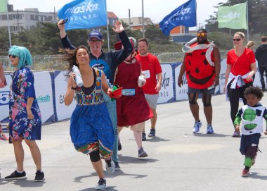 San Francisco, Ca - 20 Mayıs 2018: 107. geleneksel Bay to Breakers yarışının kimliği belirsiz katılımcıları bitiş çizgisine yaklaşıyor. Bay to Breakers kostüm giyen birçok katılımcısıyla ünlüdür..