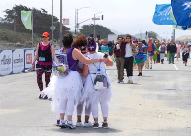 San Francisco, Ca - 20 Mayıs 2018: 107. geleneksel Bay to Breakers yarışının kimliği belirsiz katılımcıları bitiş çizgisine yaklaşıyor. Bay to Breakers kostüm giyen birçok katılımcısıyla ünlüdür..
