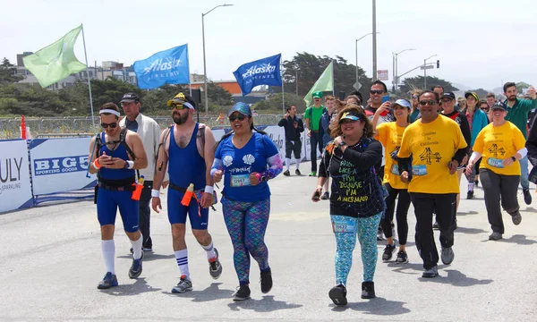 San Francisco, Ca - 20 Mayıs 2018: 107. geleneksel Bay to Breakers yarışının kimliği belirsiz katılımcıları bitiş çizgisine yaklaşıyor. Bay to Breakers kostüm giyen birçok katılımcısıyla ünlüdür..