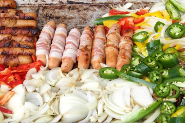 Pastırmalı sosisli sandviç, soğan, jalapeno ve açık hava ızgarasında ızgara yapan birkaç çeşit dolmalık biber. Kapat.. 