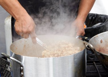 Erkek ellerine yaklaş, buharda pişmiş tavuğu büyük bir tencerede püre yap. Taco ve burrito için yemek hazırlıyorum..