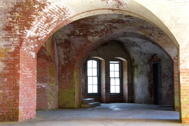 Eski tuğla yolu, çökmüş, lekeli. Geçit ışığının sonundaki pencereler parlıyor.