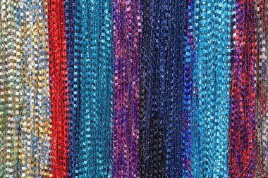 Arka plan kumaş telleri eşarp yaratıyor, birden fazla renkli eşarp sıralarda sallanıyor. sarı, kırmızı, mavi, mor, kestane rengi, su