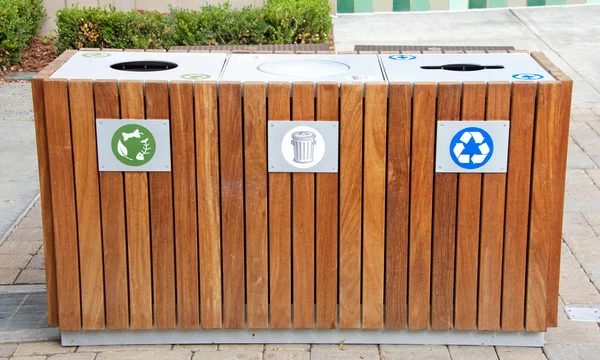 Wood enclosure for trash cans to prevent birds and other animals from spilling and digging into the trash. Composting, recycling and regular trash triple set up.