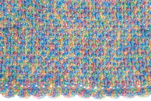 Baby blanket close up on crochet pattern alternating front loop double crochet with back loop double crochet scalloped pattern edge on base. Multicolored yarn green, blue, yellow, purple, orange.